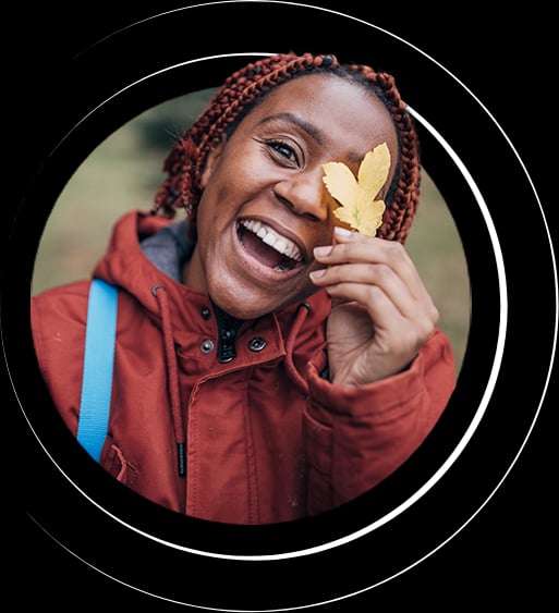 women holding leaf over her eye and laughing